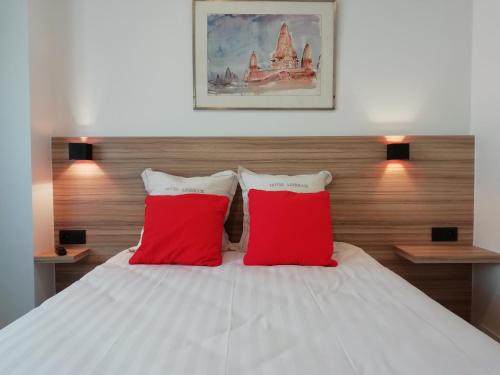 a bedroom with two red pillows on a bed at LEHOUCK kamers ontbijt in Koksijde