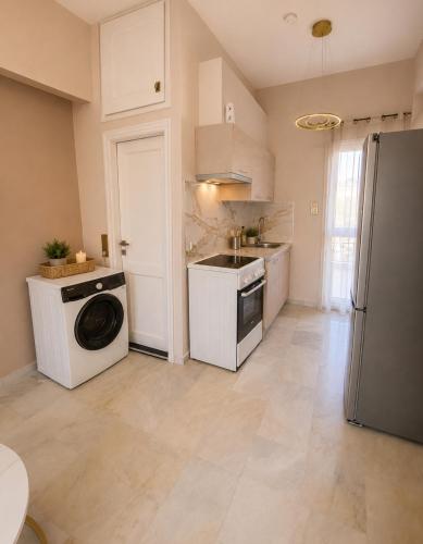 a kitchen with a washing machine and a refrigerator at Aris Studios in Karlovasi