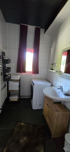a bathroom with a sink and a tub and a toilet at Ferienwohnung-Edna-Traunkirchen in Traunkirchen