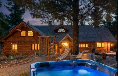 a log house with a hot tub in front of it at Fairytale Log Cabin - Homewood Forest Retreat in Alexandra