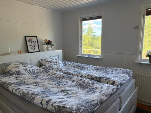 a large bed in a room with a window at Lilla stugan Orust in Svanesund