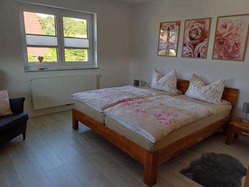 a bedroom with a bed and two windows at Ferienwohnung BlumenMeer in Karlshagen
