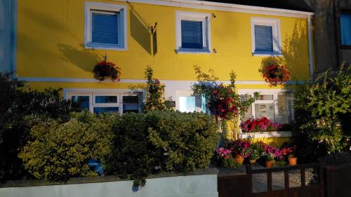 a yellow house with flowers in front of it at Globe Guesthouse in Burry Port