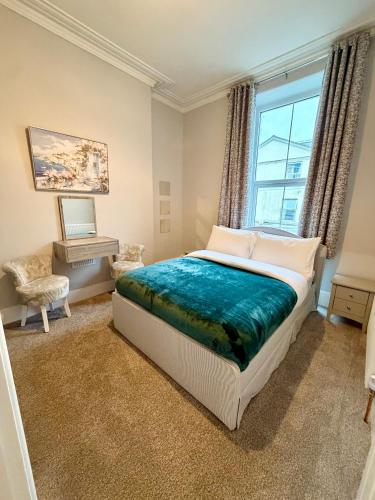 a bedroom with a large bed and a window at Homely Away in Plymouth