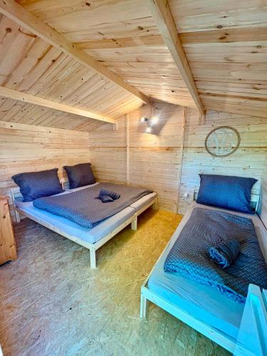 a room with two beds in a wooden cabin at Glamping 68 - Summer cottage in Kámen
