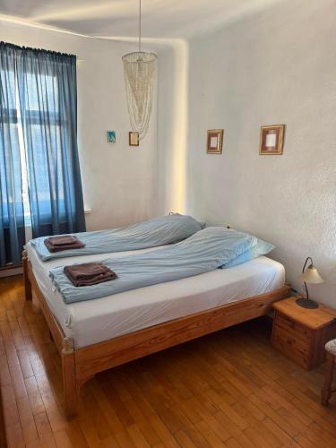 a bedroom with a bed with blue sheets and a window at Apartament Dworcowa in Kołobrzeg