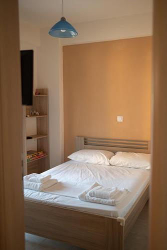 a bed with white sheets and a blue light at Solena Residences in Syvota