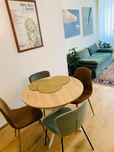 a table and chairs in a living room with a couch at the window in Domodossola