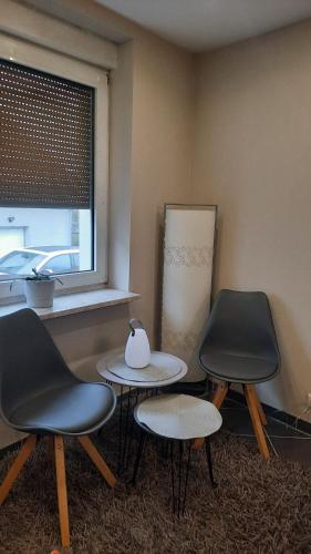 two tables and two chairs in a room with a window at Gästezimmer Heinebach in Alheim