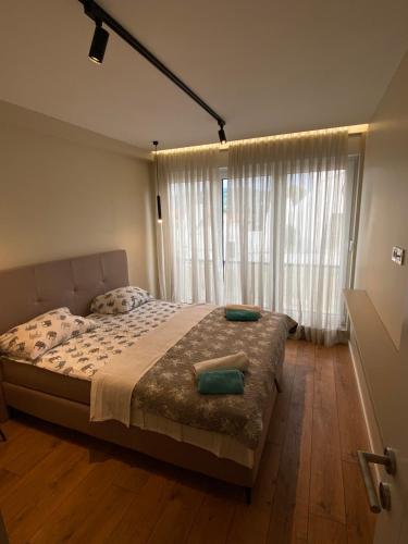 a bedroom with a bed and a large window at Vista Visoko Apartants in Visoko