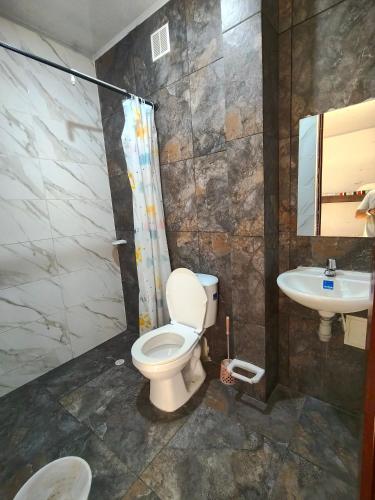 a bathroom with a toilet and a sink at Villa Tania in Melgar