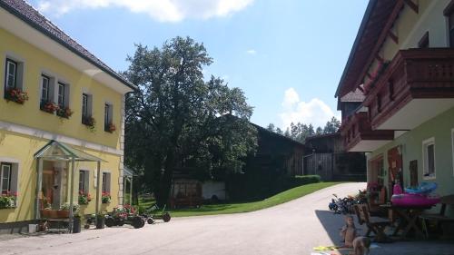 a road between two buildings with motorcycles parked on the side at ERLEBNISBAUERNHOF Steinerhof in Kärnten in Liebenfels