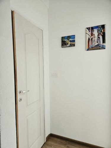 an empty room with a door and two pictures on the wall at Hikers place in Sutomore