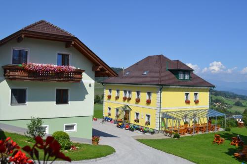 a couple of buildings with flowers on the balconies at ERLEBNISBAUERNHOF Steinerhof in Kärnten in Liebenfels