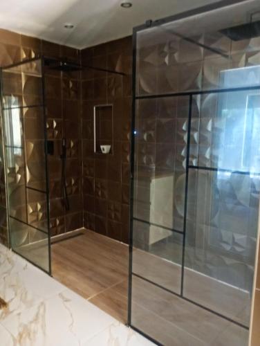 a shower stall with glass doors in a bathroom at Iris in Valras-Plage