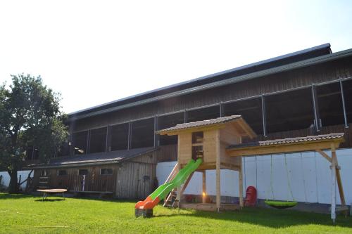 a playground with a slide in front of a building at ERLEBNISBAUERNHOF Steinerhof in Kärnten in Liebenfels