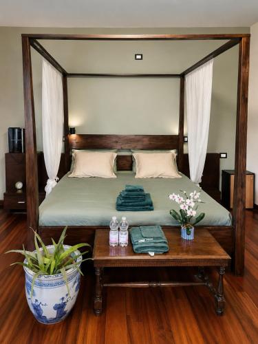 a bedroom with a bed with a wooden frame and a table at Villa Vinea Prisca B&B - Bergamo Hill in Cenate Sotto