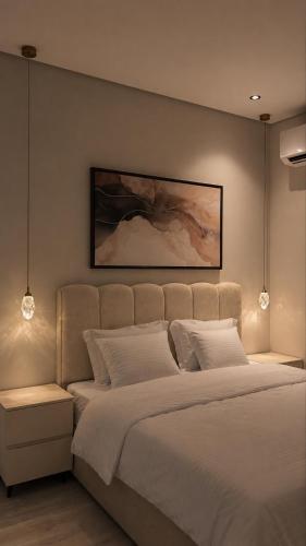 a bedroom with a large bed and a painting on the wall at Sukoon in Dammam