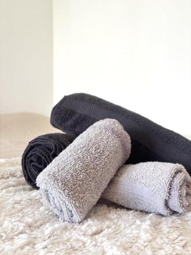 a pile of towels sitting on top of a bed at Bricks Pérignon - Tram, lit Queen size & air fryer in Chenôve