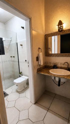 a bathroom with a shower and a sink and a toilet at Cantinho Da Go in Caraguatatuba