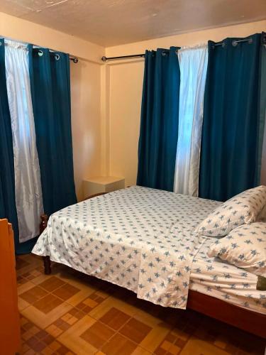 a bedroom with blue curtains and a bed in a room at Little Escape in The Lime