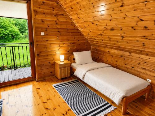 a room with two beds in a wooden cabin at Morenowa Dolina Rusinowo in Rusinowo