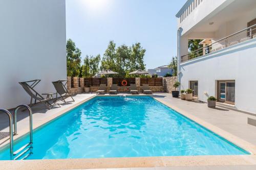 a swimming pool in the backyard of a house at Villa Gagra - Villa by the Sea with a Private Pool in Panormos Rethymno
