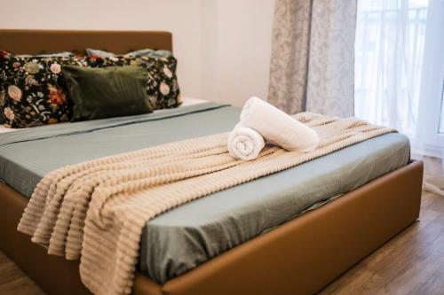 a bed with a blanket and a towel on it at Seyra Olive Studio in Ştefăneştii de Sus