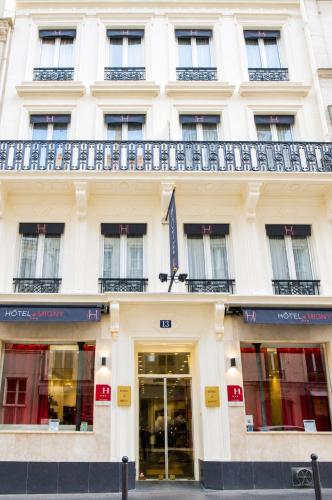 a white building with a balcony on top of it at Hotel Migny Opéra Montmartre in Paris