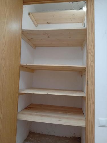 a cupboard with wooden shelves in a room at Apartmento El Descanso in Rincón de Soto