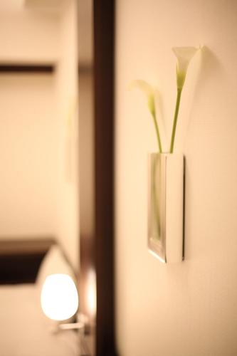 a vase with flowers in it on a wall at Furano Natulux Hotel in Furano