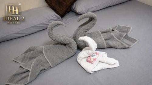two towel swans on top of a bed at Hotel ideal 2 in Inocência