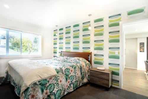 a bedroom with a bed and a wall of surfboards at Waikanae Beach Suite Retreat in Waikanae