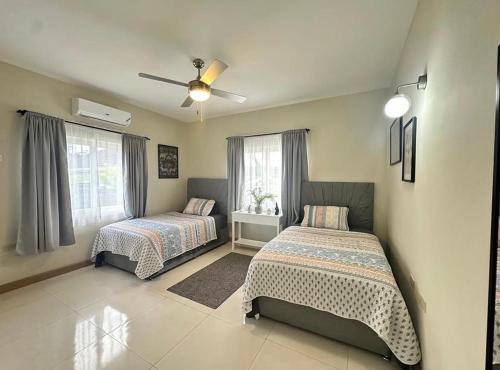a bedroom with two beds and a ceiling fan at Villa cool breeze in Steer Town