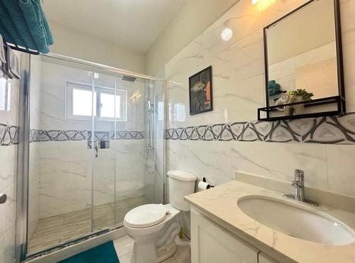 a bathroom with a shower and a toilet and a sink at Villa cool breeze in Steer Town