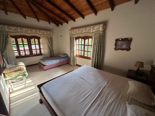 a bedroom with a large bed and two windows at La muñeca Chalet in Circasia