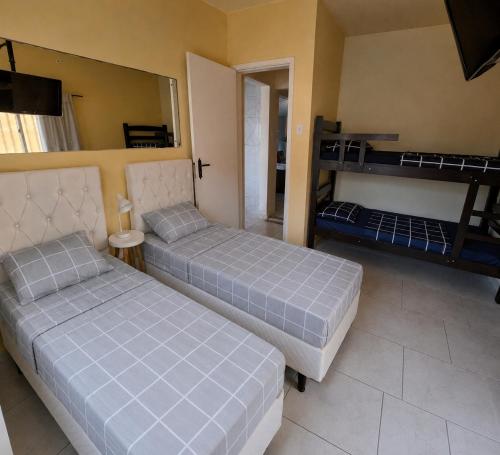 two beds in a room with two bunk beds at Aconchego do Amor com Suíte com piscina in Pelotas