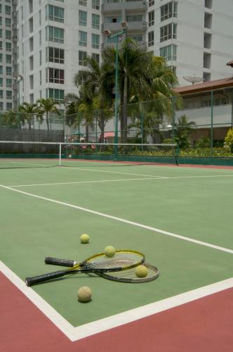 a tennis racket and balls on a tennis court at The Residences at Puri Casablanca in Jakarta