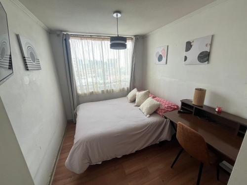 a bedroom with a bed and a desk and a window at Habitaciones con C in Concepción