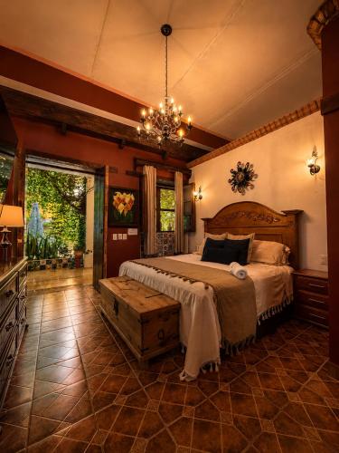 ein Schlafzimmer mit einem großen Bett und einem Kronleuchter in der Unterkunft Copa de Oro Hotel Boutique in Mascota