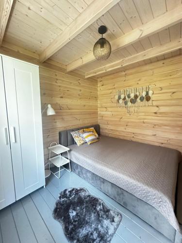 a bedroom with a bed in a wooden cabin at Kregžlės slėnis in Skirlėnai