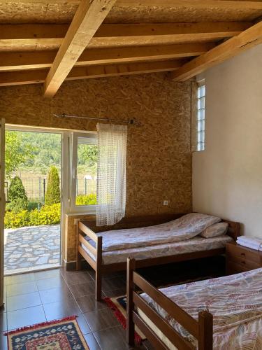 a bedroom with two beds and a large window at Lola Guest House in Vusanje