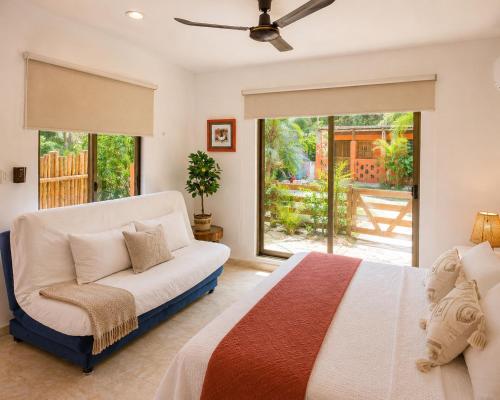 a bedroom with a bed and a couch and a window at Apartment with jacuzzi and beach club access in Telchac Puerto