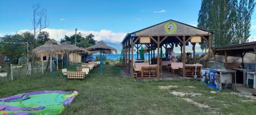a gazebo with chairs and tables in the grass at Camper Park Lake View in Mëmëlisht