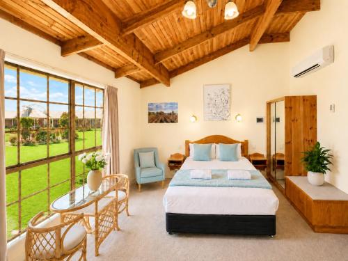a bedroom with a bed and a table and chairs at Coonawarra Place Motor Inn in Coonawarra