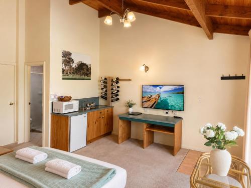 a living room with a desk and a tv on the wall at Coonawarra Place Motor Inn in Coonawarra