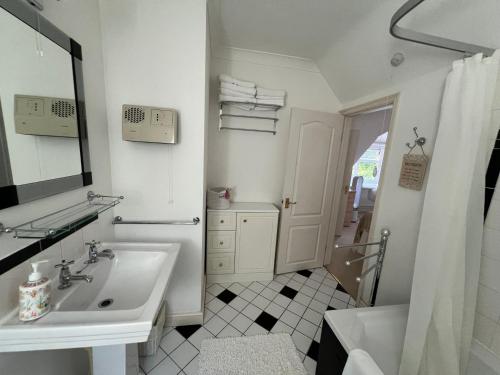 a white bathroom with a sink and a mirror at Hidden cottage in Abingdon