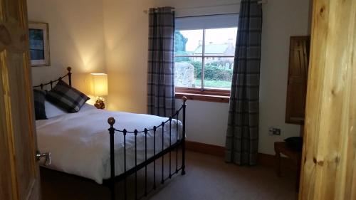 a bedroom with a large bed and a window at The Birdcage Guest House in Cornhill-on-tweed