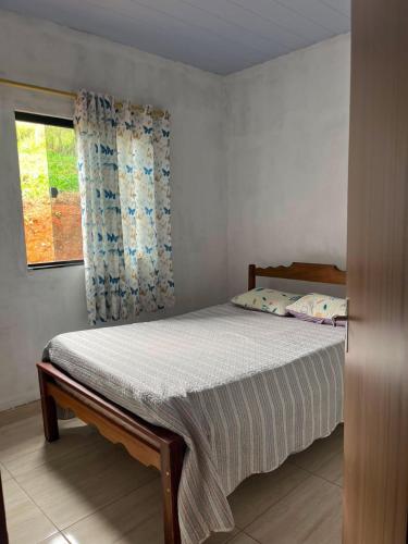 a bed in a bedroom with a window at Aconchego Da Serra in Triunfo