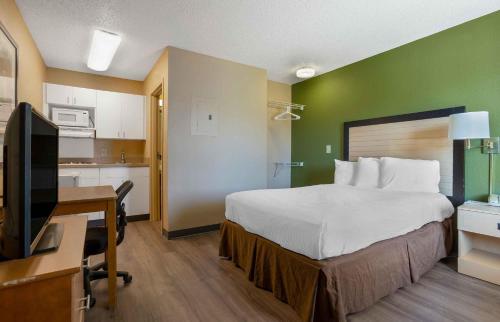 a hotel room with a bed and a desk with a computer at Extended Stay America Suites - Houston - The Woodlands in The Woodlands